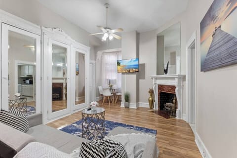 Bright and inviting living room featuring a large sofa, flat-screen TV, and plenty of natural light.
