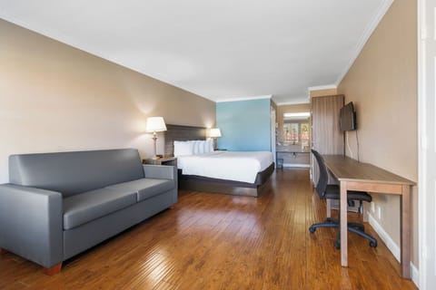 Unwind on plush bedding with sofa lounge and workspace.