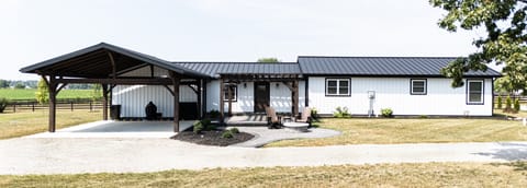 Entry door covered parking with firepit and pergola.
