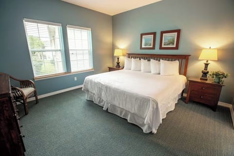 Settle into a serene bedroom with bright windows and lamps.