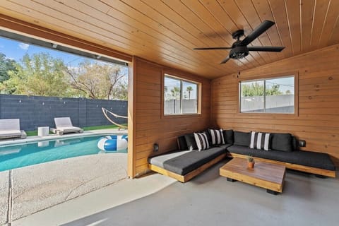 Whether you're unwinding with a good book, engaging in friendly conversations, or playing games with fellow guests, this communal space offers comfort and connection for a memorable stay.   Patio Lounge Area with Wood Ceiling