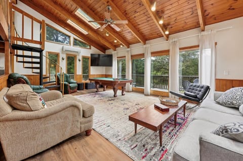 Gather in the sun-filled living room with soaring wood ceilings, skylights, and a pool table nearby.