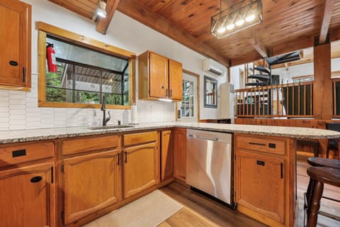The warm wood kitchen features plenty of cabinet space and all the essentials for home cooking.