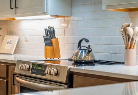 Thoughtful touches in the kitchen include modern cookware, knife set, and a welcoming home feel.