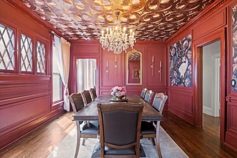 Sun-filled dining room with tall windows, intricate architectural details, and a long dining table—perfect for hosting meals near Midtown Kansas City attractions.