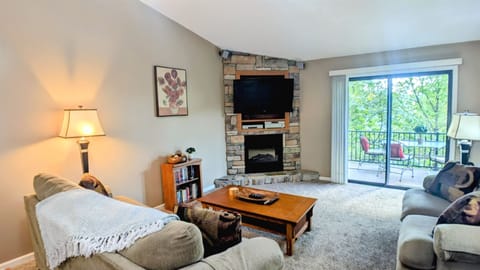 Living area with electric fireplace and access to back terrace