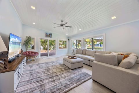 Spacious living room with large windows offering views of the waterfront and natural light.