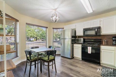 Green cushions, black cabinets, and a chandelier that’s fancier than your dinner plans.