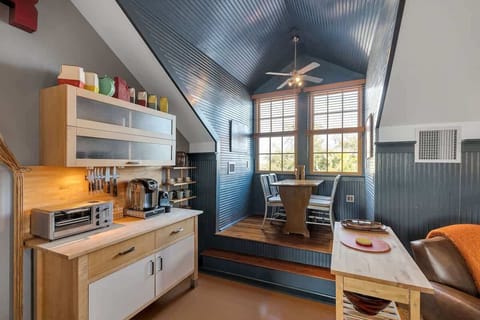 Charming elevated dining nook with large windows, wood floors, and built-in character, perfect for enjoying meals in a bright, intimate setting.