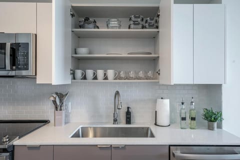 Fully stocked modern kitchen with utensils, cookware, and tableware.