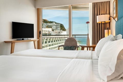 Unwind with a movie while waves shimmer outside.