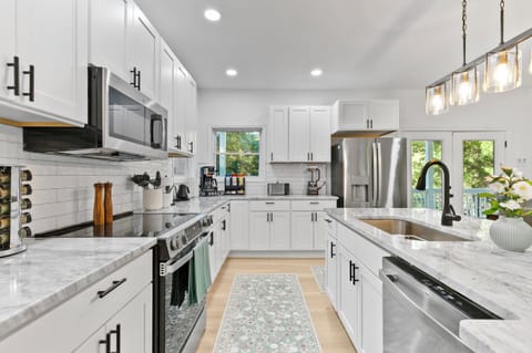 Fully stocked kitchen with cookware, dishes, utensils, coffee station