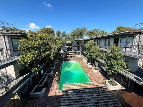 Community outdoor lounge with shaded seating, BBQ grill, and poolside relaxation area. A perfect spot to gather, cook out, or unwind under the pergola.