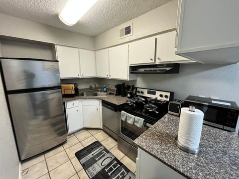Fully equipped kitchen with stainless steel fridge, stove, oven, microwave, and dishwasher. Stocked with cookware, dishes, and essentials for cooking or dining in. Perfect for preparing meals during your stay.