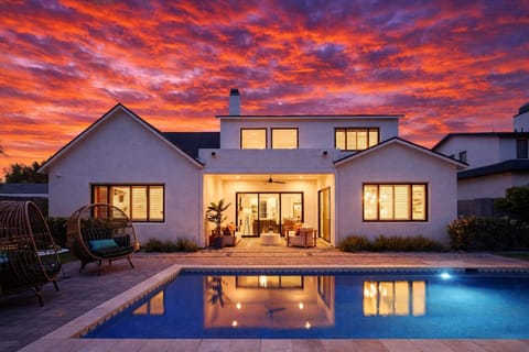 Private backyard with a sparkling pool and a covered patio with outdoor seating.