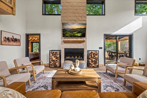 Spacious living room with modern fireplace and neatly stacked firewood