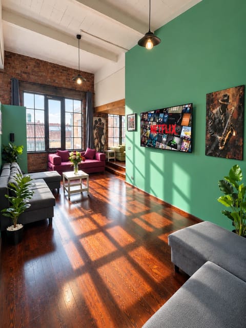 Spacious living area filled with natural light, combining original industrial character with comfortable modern seating.