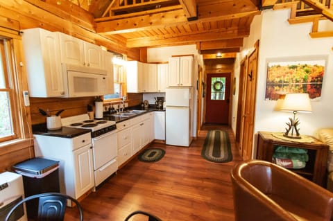 Kitchen with refrigerator, small stove, microwave, toaster, and coffee maker.