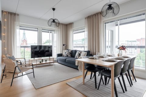 Relax in this bright, modern living room featuring large windows and a stunning view of the historic city church.