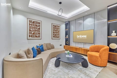 A spacious living room featuring plush seating, a smart TV, and elegant decor, perfect for relaxing or entertaining.
