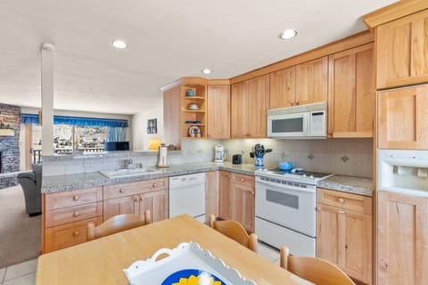 Fully stocked kitchen with white appliances.