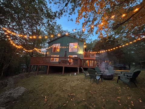 Cozy mountain retreat with a spacious deck, glowing string lights, & a fire pit