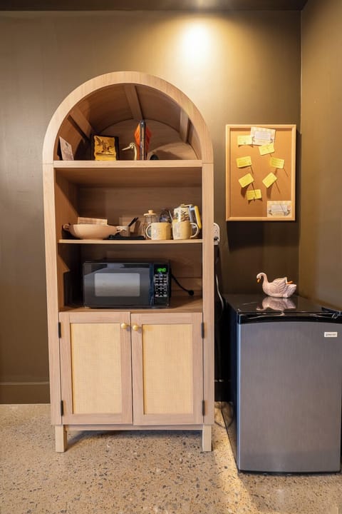 Coffee station with locally roasted coffee, locally sourced tea, french press, hot water kettle, locally made pottery mugs, microwave, mini fridge