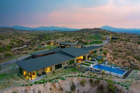 Estate 3 - Stunning private oasis featuring a sparkling heated infinity pool and spa with sun loungers, a patio with a BBQ grill, multiple lounge areas, and fire pits surrounded by unparalleled desert views.