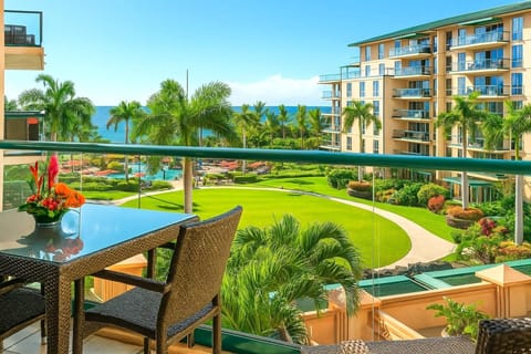 Scenic lanai dining with lush resort landscaping, mountain-lined horizon, and distant ocean sparkle. HKH-423