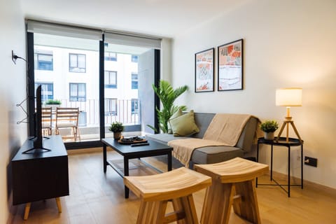 Cozy living area with balcony access, perfect for relaxation and enjoying city views.