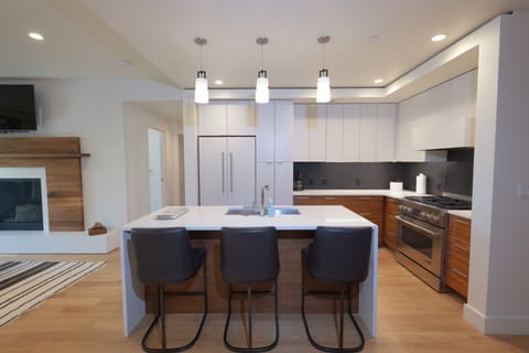 Your dream kitchen awaits with sleek modern design, warm wood accents, and a spacious island perfect for morning coffee or evening meals with friends.