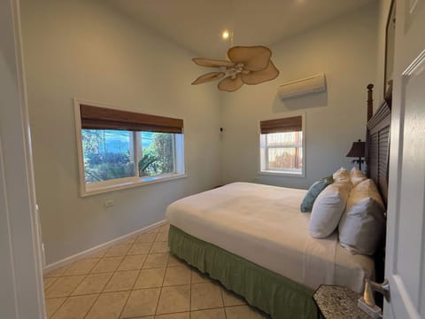 King Bed with views of the ocean, garden and island of Molokai. AC comfort. Door separates the bedroom from the suite's private living room & bath.