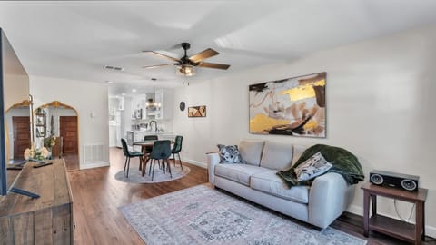 Cozy, modern living and dining room combo with sleek furniture and warm tones. Features a large TV, comfy seating, and a stylish dining area. Perfect for relaxing or gathering, this open layout blends comfort and function seamlessly.