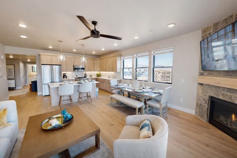 Relax in your spacious open-concept living space where modern comfort meets mountain charm, featuring a cozy fireplace and fully-equipped kitchen.