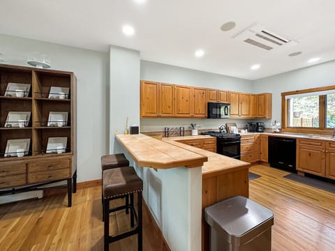 Gather around this spacious kitchen island while dinner simmers - the heart of your mountain home. With every appliance and tool you`d find at home, plus stunning window views, cooking becomes part of the vacation experience