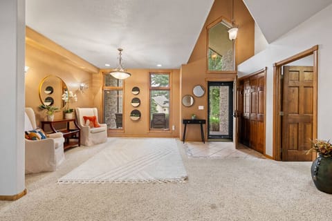 A spacious area with large windows, wall-hanging ornaments, and two elegant chairs creating a bright and stylish atmosphere.