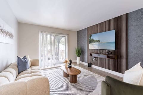 The perfect place to relax and unwind featuring a stylish living room with natural light, smart TV, and elegant decor. Where comfort meets style