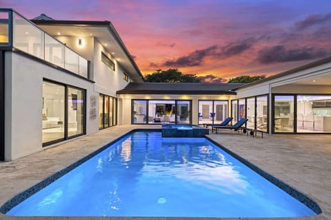 Evening swim in private pool beautiful home facade stylish patio and glowing horizon