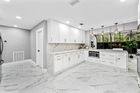 Spacious kitchen area featuring chic tile crisp counters and generous storage