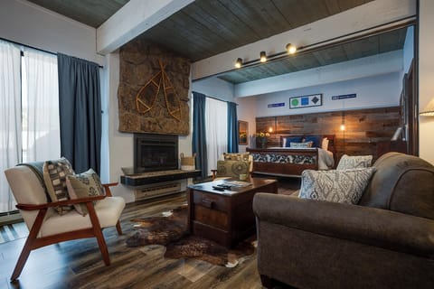 Unwind in this cozy living space where rustic wood beams meet modern comfort, featuring a crackling fireplace for ultimate relaxation.