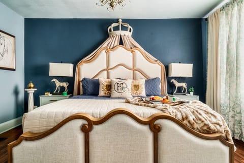 Experience royal elegance in this luxurious bedroom, complete with a crown-topped headboard, soft linens, and ambient lighting for a serene escape. One King Bed | Ensuite Bathroom with a Stand Up Shower!