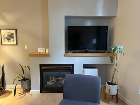 Relax in this bright, open-concept living space featuring floor-to-ceiling windows and a cozy gas fireplace for those cool West Coast evenings.