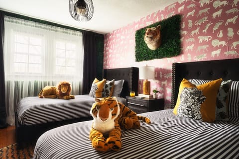 [Bedroom 3- Jungle Room] Upstairs, the Jungle Room offers two twin beds for a playful slumber party or a cozy night`s sleep after exploring Discovery Place! Enjoy the added convenience of a Roku-enabled Smart TV in this room.
