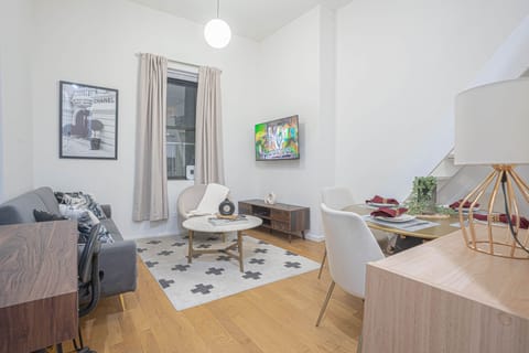 Cozy living area with smart TV, dining table, stylish décor and open layout connecting kitchen and l