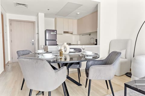 Open kitchen with marble dining table and cushioned velvet dining chairs.