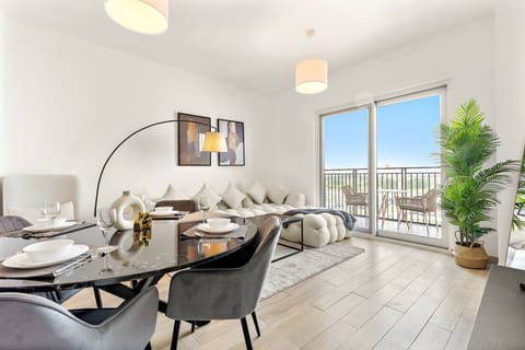 Bright lounge with plush sofa, balcony access, and stylish dining setup.