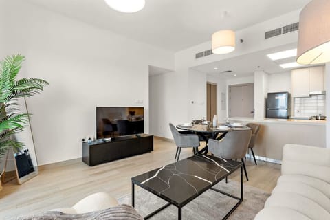 Stylish living area with TV, dining space, and natural light-filled design.