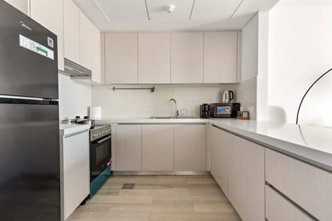 Modern kitchen with full-size appliances, light cabinetry, and sleek design.