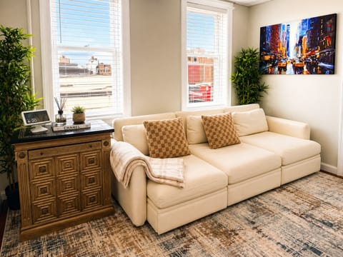Bright lounge with city views, plush sectional, artful modern decor