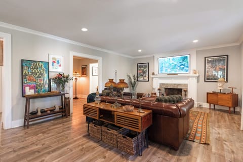 Spacious living room with a cozy leather sofa and curated vintage décor.